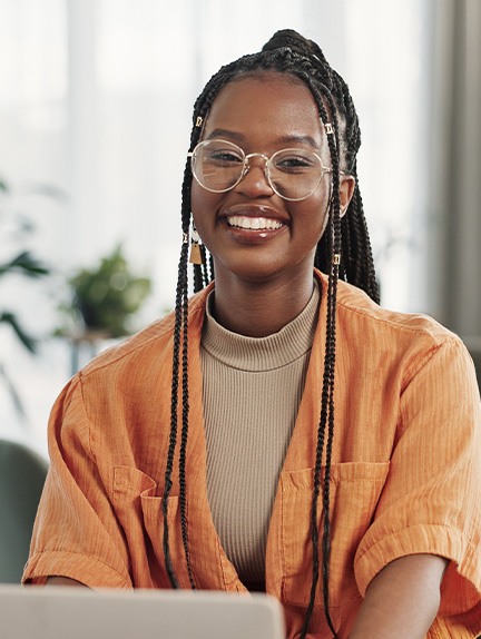 Woman smiling while working on laptop at home