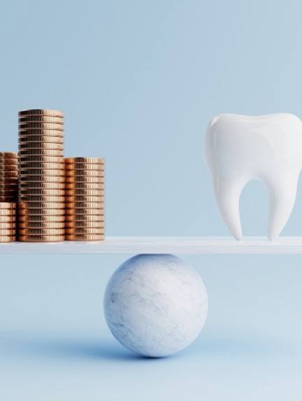 Tooth balanced against stacks of coins on scale