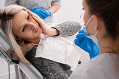 Lady with oral pain looks at orthodontist