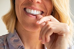 Lady smiles while wearing Invisalign