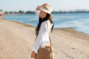 Woman on the beach looking over shoulder and smiling